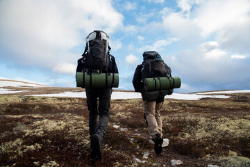 Hiking in the Scandinavian Mountains. Two men in the mountains go to the top