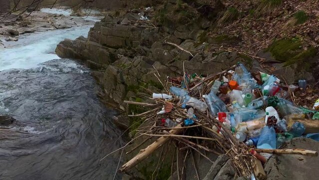 uncultured people throw garbage into the river, fast water carries polyethylene and other non-degradable waste of civilization into large rivers, littering their banks with plastic.