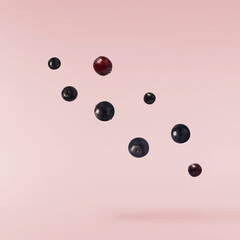 Fresh ripe elderberry falling in the air isolated on pink background. Food levitating or zero...