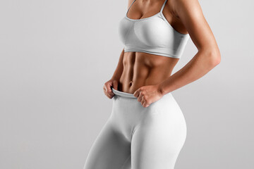 Fitness woman showing abs and flat belly. Beautiful athletic girl, shaped abdominal