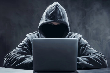 Man hiding his identity works behind laptop hacking personal data, hacker
