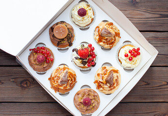 Vanilla, chocolate and peanut butter cupcakes with salted caramel, fresh raspberry, strawbeery and red currant in gift paper box
