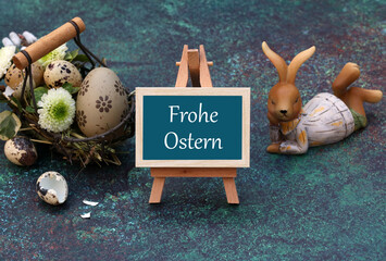 Grußkarte Frohe Ostern.Der Text Frohe Ostern auf eine Tafel geschrieben mit Ostereiern und einem...