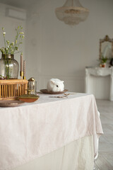 A small white rabbit sits on a table in a white room