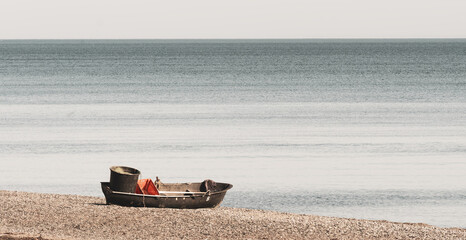 lone fishing rowboat on sea shore