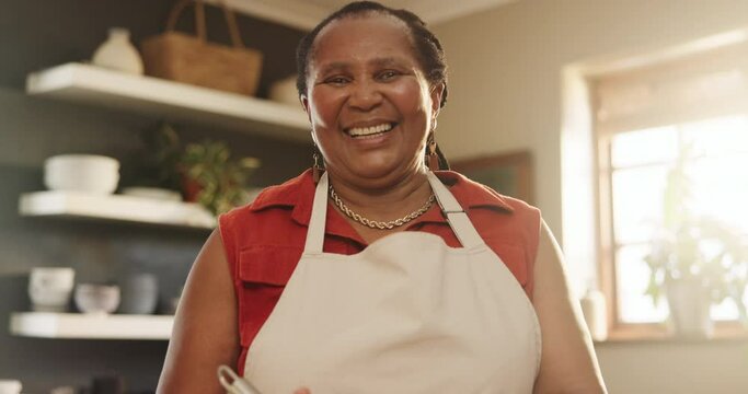 Senior, woman and happiness for baking in kitchen with whisk, bowl and apron for cake, cookies and face. Elderly, african person and portrait with smile for cooking, chef and retirement fun in home