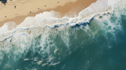 Aerial view of a paradise beach where the waves of the sea break on the shore. Top view of a beautiful  sandy coast with turquoise blue water and white foam on sunny day. Summertime, travel.