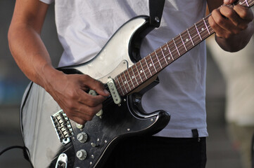 Fototapeta premium Man playing music in a black guitar, doing rock and roll style