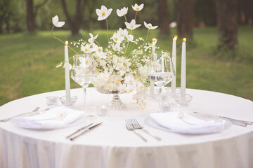 White bouquet of anemones on a served table in the summer in the garden