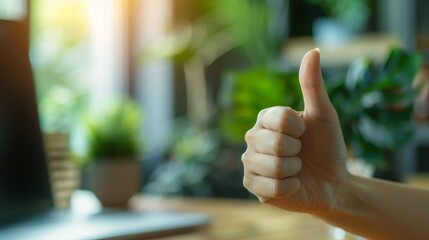 Thumbs up sign. Woman's hand shows like gesture. Home office background