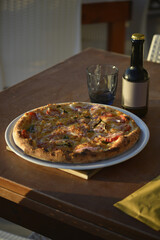 pizze servite al tavolo all'aperto in riva al mare con birre artigianali - 760994040