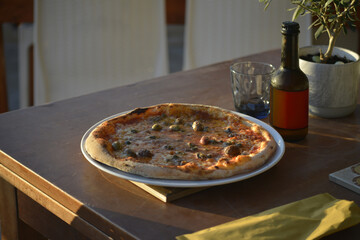 pizze servite al tavolo all'aperto in riva al mare con birre artigianali - 760994061
