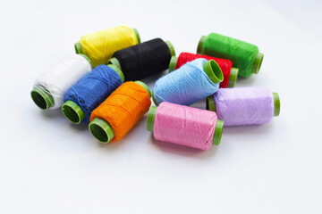 Colourful thread spools on white background