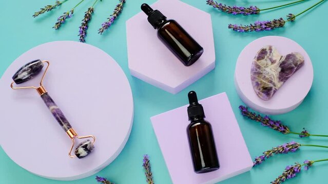 Lavender oil in glass dark bottles and gua sha roller and scraper. 4k footage