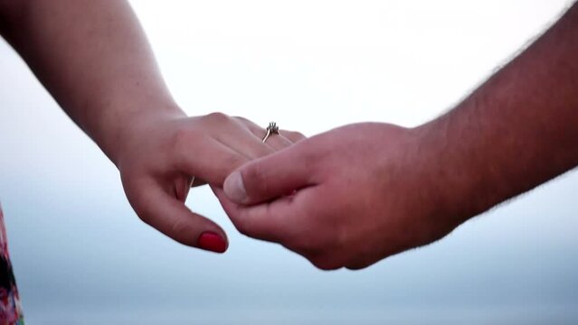 Man gently holds the hand of his beloved girl on whose finger there is a ring. Marriage proposal 
panorama