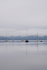 Fototapeta na wymiar Boats in front of the shore of Cowichan Bay during a winter season on Vancouver Island in British Columbia, Canada