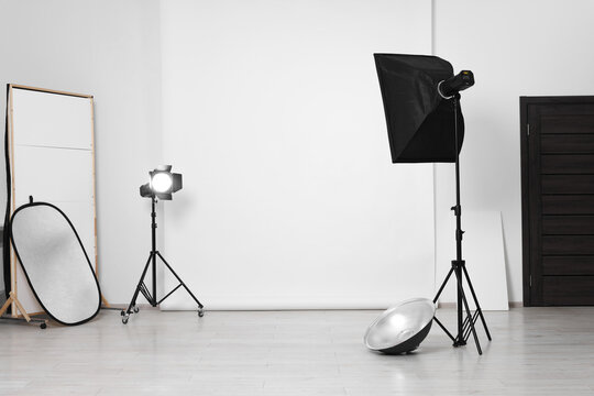 White photo background and professional lighting equipment in studio