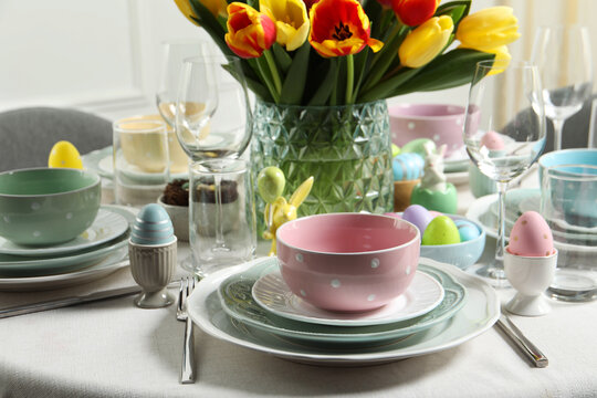 Easter celebration. Festive table setting with beautiful flowers and painted eggs