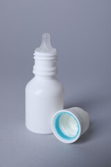 Bottle of medical drops on gray background