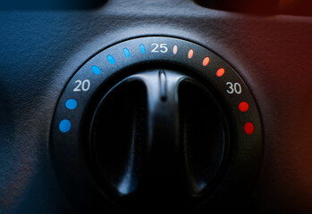 close-up of a car's climate control knob, with warm and cool colors on the sides