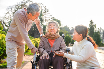 portrait asian female 80 years sit on wheelchair while family take care of her in the park,concept of family lifestyle,elderly health care,relationship