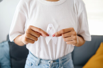 Female wear white casual t-shirt and holding white ribbon for November Lung Cancer Awareness month