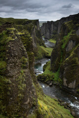 Fototapeta na wymiar Scenic, mossy Fjadrargljufur canyon in south Iceland during moody overcast day and heavy rain clouds.