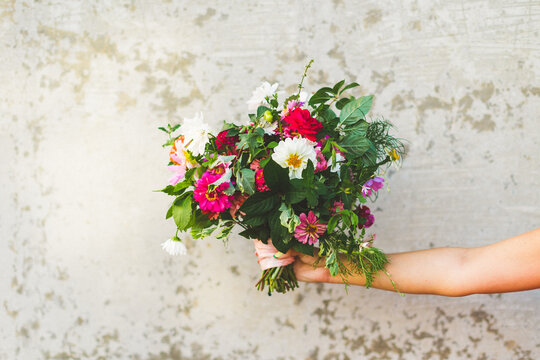 Garden Bouquet with Pink Ribbon Held by Textured Cement Wall, Colorful Wedding Bouquet with Lots of Greenery