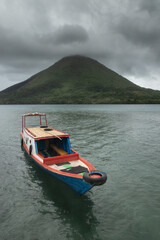 Small passenger boat and scenic Bandaneira volcano of Banda islands, Maluku Regency, Indonesia