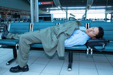 Businessman sleeping at airport in between flights 