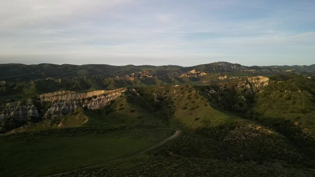 Aerial of beautiful rolling green hillsides in Simi Valley California at sunset