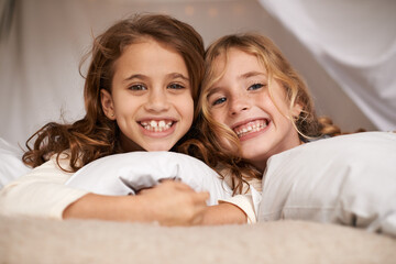 Excited, sleepover and portrait of children in bedroom for playing, bonding and relax with toys in home. Happy, friends and young girls on bed in tent or blanket fort for childhood, fun and happiness