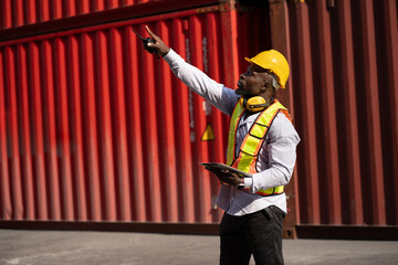 African logistic engineer man worker or foreman working direct driver forklift container at container site	 - 761121615