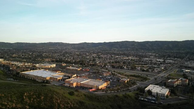 Aerial around shopping center and neighborhoods at sunset in Simi Valley California on highway 118
