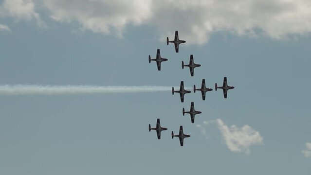Snow bird planes fling by in formation.