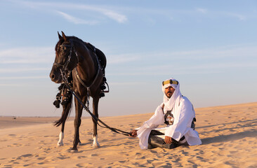 Saudi man in a desert with his horse