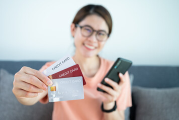 Asian woman showing her credit cards.