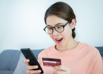 Asian woman having feels good after buying somethings online by credit card. A credit card is a type of credit facility, provided by banks that allow customers to borrow funds.