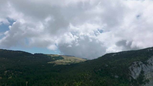 Valley of pine in mountain with clouds, French Alps