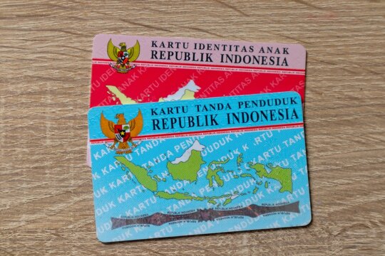 Jakarta, Indonesia - March 13, 2024: The Indonesian identity card and The Indonesian child identity card isolated on wooden background