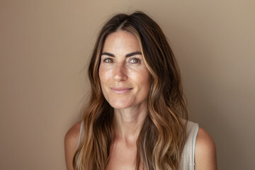Naklejka premium Woman portrait in her mid thirties isolated from a beige copyspace background