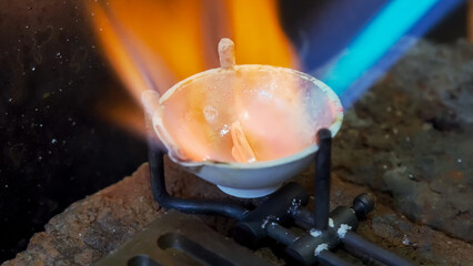 Wedding jewelry handicraft. Goldsmith melting silver with gas torch bright flame