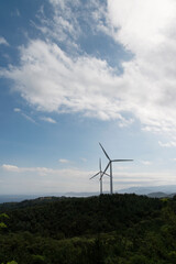 View of the wind turbine on the hill against the sky background