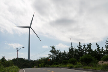 View of the wind turbine on the hill against the sky background