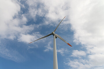 View of the wind turbine on the hill against the sky background