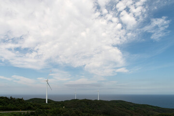 View of the wind turbine on the hill against the sky background