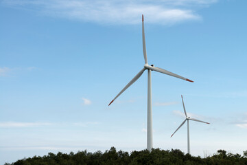 View of the wind turbine on the hill against the sky background
