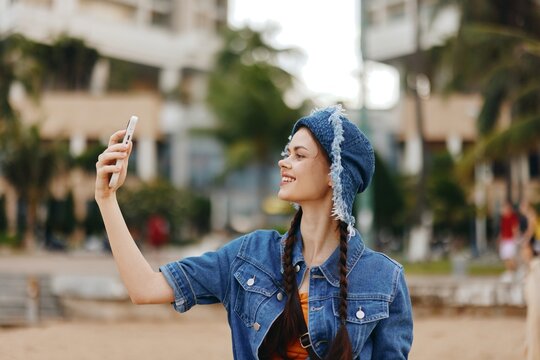 Pretty Young Female Posing for a Selfie with Smartphone in Urban City Street, Capturing a Stylish Summer Portrait