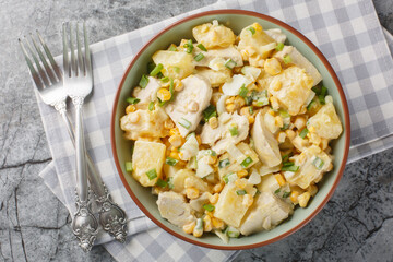 Chicken pineapple salad with corn, cheese, eggs and onions dressed with mayonnaise close-up in a...