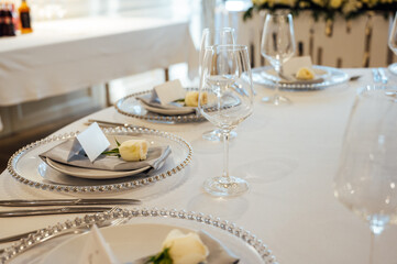 A very beautiful festive table with candles, plates and glasses. Cool room decor